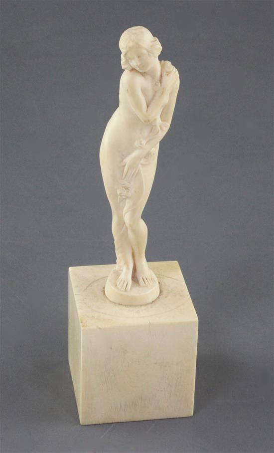 A Joe Descomps carved ivory figure of a standing nude woman holding a floral garland, height 5in.